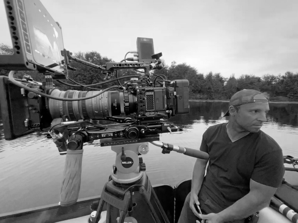 Stef on set with a cinema camera on a boat